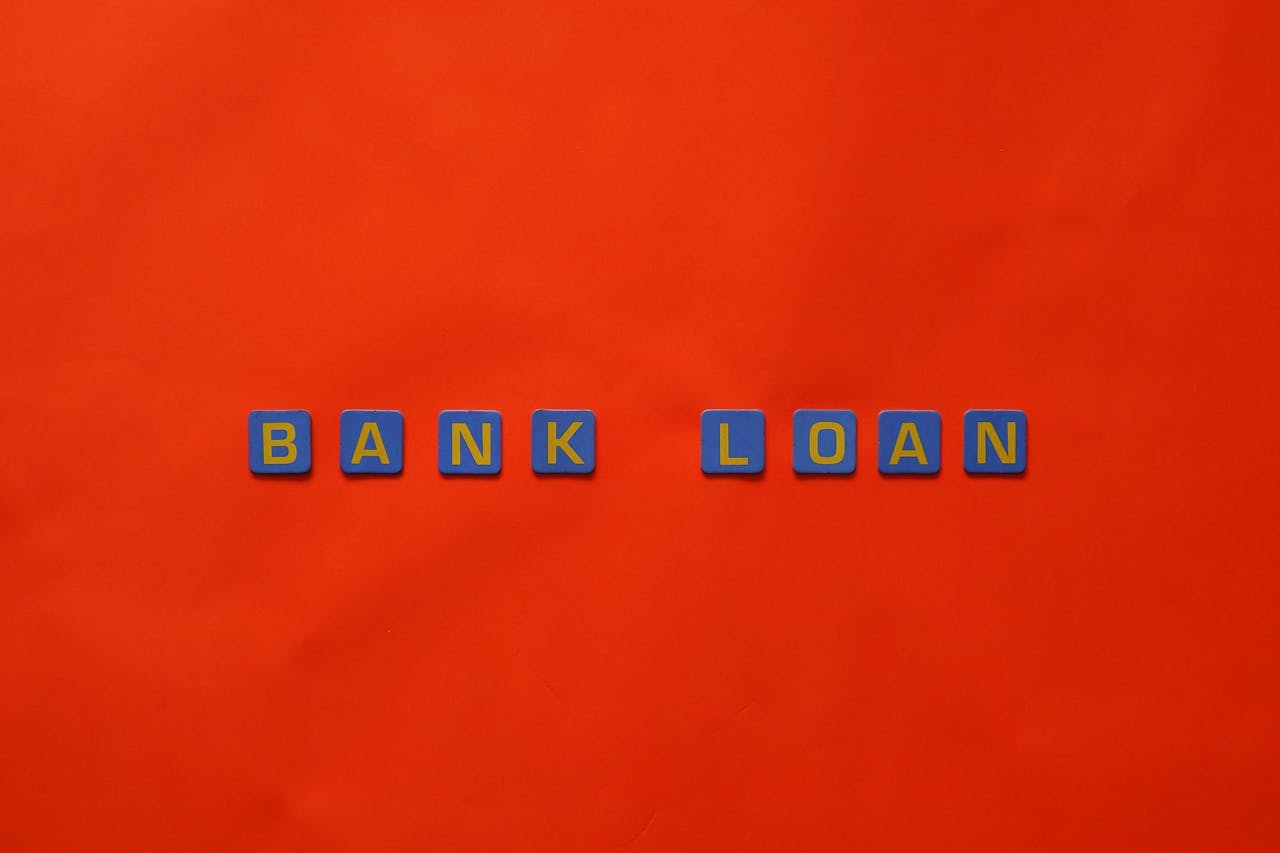 Letters forming Bank Loan on a vibrant red surface, ideal for finance themes.